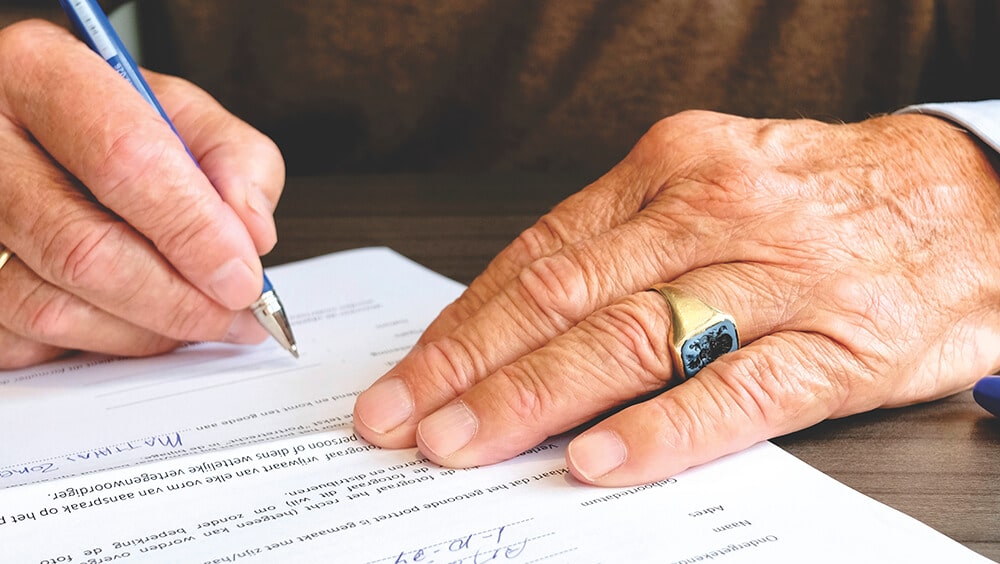 Close up of person's hands as they sign a document